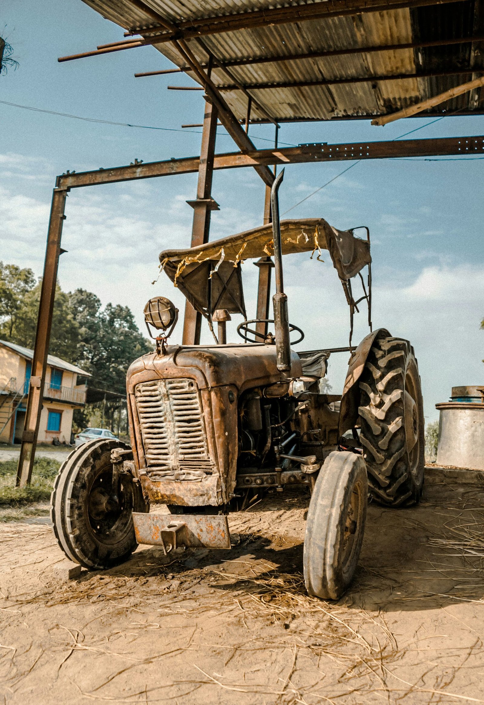 an old tractor is parked under a roof